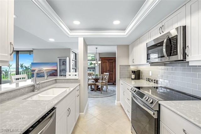 300 S Collier Blvd Unit 303, Marco Island, FL 34145 - kitchen featuring stainless steel appliances, backsplash, white cabinets, a raised ceiling, and recessed lighting