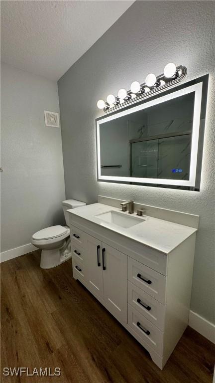 11530 Villa Grand Unit 1101, Fort Myers, FL 33913 - bathroom with vanity, wood finished floors, a textured ceiling, a shower, and a textured wall