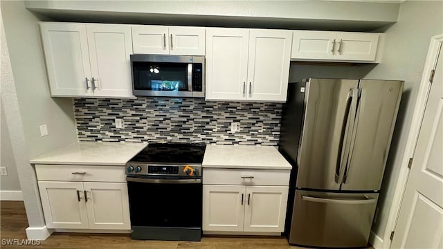 11530 Villa Grand Unit 1101, Fort Myers, FL 33913 - kitchen with appliances with stainless steel finishes, white cabinets, light countertops, and light wood-style flooring