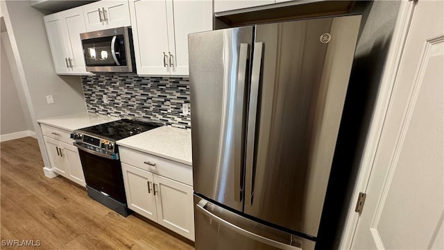 11530 Villa Grand Unit 1101, Fort Myers, FL 33913 - kitchen with stainless steel appliances, light wood-type flooring, decorative backsplash, light countertops, and white cabinets