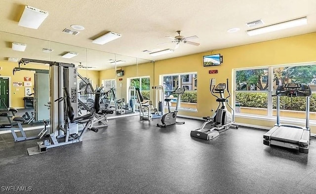 11530 Villa Grand Unit 1101, Fort Myers, FL 33913 - exercise room featuring plenty of natural light, a ceiling fan, and a textured ceiling