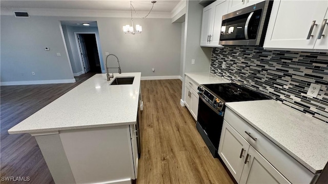 11530 Villa Grand Unit 1101, Fort Myers, FL 33913 - kitchen featuring stainless steel microwave, black electric range, ornamental molding, an island with sink, and dark wood finished floors