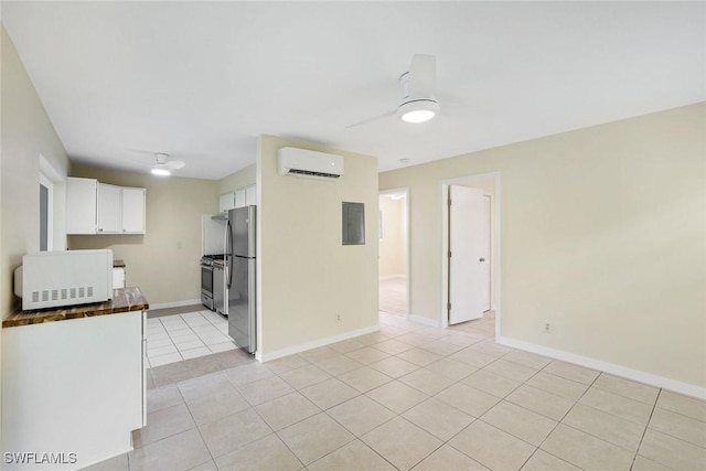 527 Goodland Drive W, Goodland, FL 34140 - kitchen featuring stainless steel appliances, a wall mounted air conditioner, light tile patterned flooring, white cabinetry, and a ceiling fan