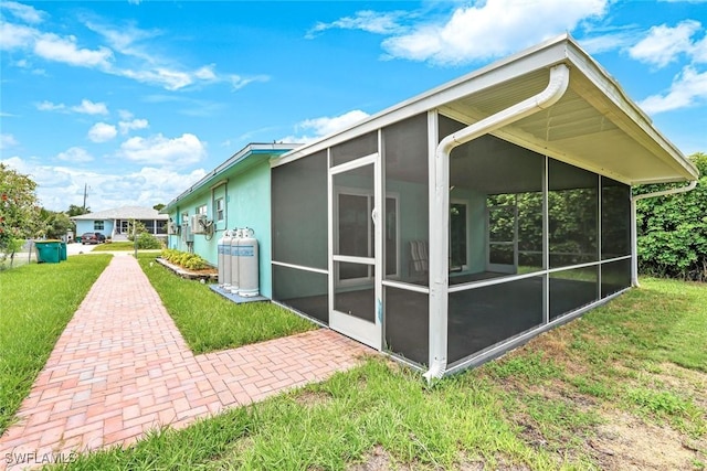 527 Goodland Drive W, Goodland, FL 34140 - view of property exterior featuring a sunroom, a lawn, and stucco siding