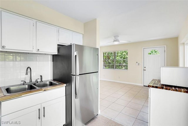 527 Goodland Drive W, Goodland, FL 34140 - kitchen featuring freestanding refrigerator, tasteful backsplash, a ceiling fan, light tile patterned flooring, and white cabinetry