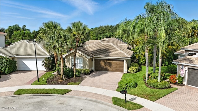 1381 Areca Cv, Naples, FL 34119 - view of front of property with a tile roof, decorative driveway, stucco siding, a front lawn, and an attached garage