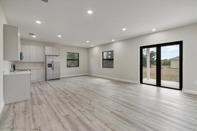 unfurnished living room with recessed lighting and light wood-type flooring
