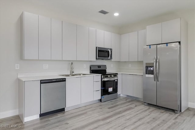 kitchen featuring appliances with stainless steel finishes, light wood-type flooring, light countertops, and recessed lighting