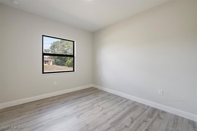 spare room with light wood-type flooring and baseboards