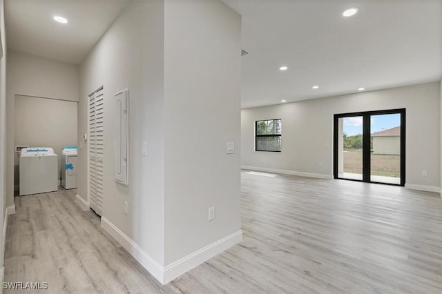 hall featuring independent washer and dryer, light wood-style flooring, and recessed lighting