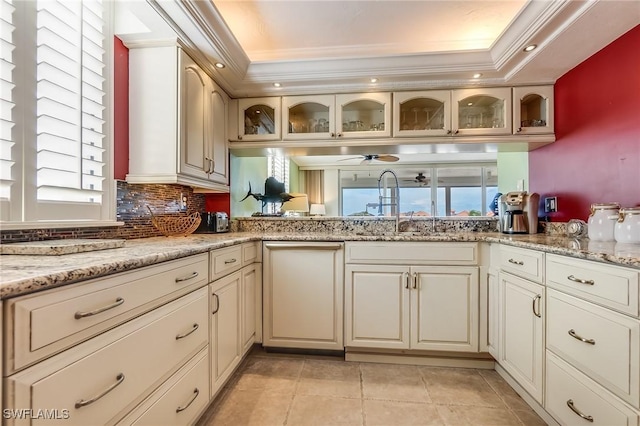 4745 Estero Blvd Unit 302, Fort Myers Beach, FL 33931 - kitchen featuring a raised ceiling, ornamental molding, light tile patterned floors, glass insert cabinets, and decorative backsplash