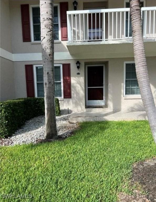 850 Elkhorn Ct Unit 213, Marco Island, FL 34145 - view of exterior entry featuring stucco siding and a balcony