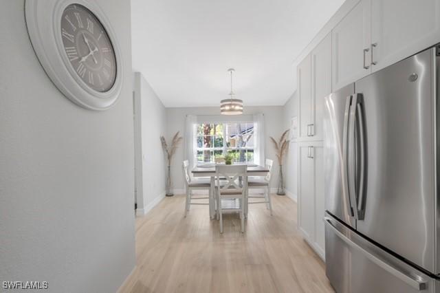 3505 Avion Woods Ct Unit 902, Naples, FL 34104 - dining room with baseboards and light wood-style flooring