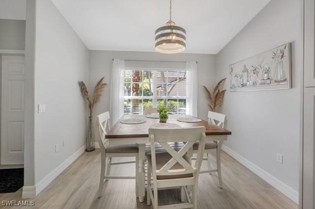 3505 Avion Woods Ct Unit 902, Naples, FL 34104 - dining room featuring vaulted ceiling, light wood-type flooring, and a chandelier