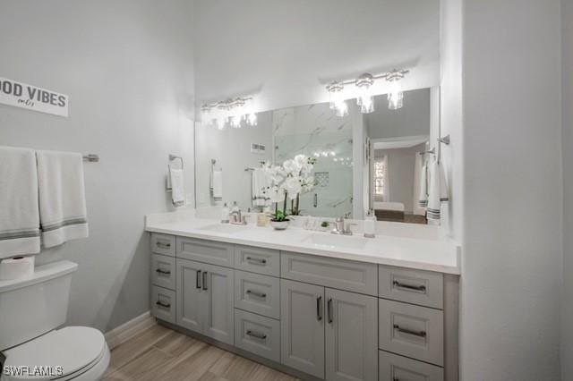 3505 Avion Woods Ct Unit 902, Naples, FL 34104 - bathroom featuring double vanity, a shower, and wood finished floors