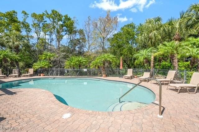 3505 Avion Woods Ct Unit 902, Naples, FL 34104 - community pool featuring a patio area and view of scattered trees
