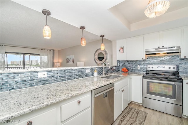400 Lenell Rd Unit 207, Fort Myers Beach, FL 33931 - kitchen with stainless steel appliances, under cabinet range hood, backsplash, white cabinets, and light wood-style flooring