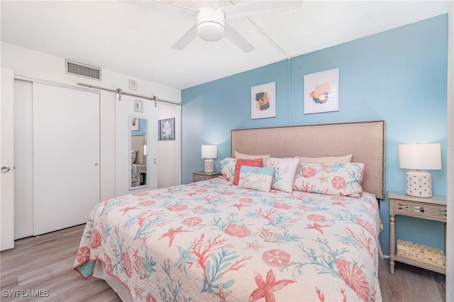 400 Lenell Rd Unit 207, Fort Myers Beach, FL 33931 - bedroom with wood finished floors, a barn door, a closet, and ceiling fan