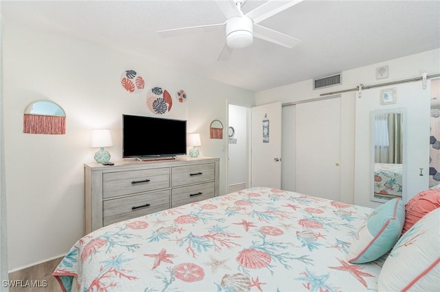 400 Lenell Rd Unit 207, Fort Myers Beach, FL 33931 - bedroom with wood finished floors, a closet, a barn door, and ceiling fan