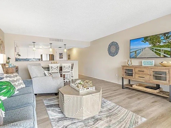 400 Lenell Rd Unit 207, Fort Myers Beach, FL 33931 - living area featuring wood finished floors and a textured ceiling