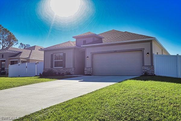 3393 Kacher Rd, North Port, FL 34288 - view of front of property with stone siding, stucco siding, a garage, and driveway