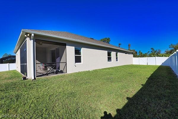3393 Kacher Rd, North Port, FL 34288 - back of property featuring a fenced backyard, stucco siding, and a sunroom