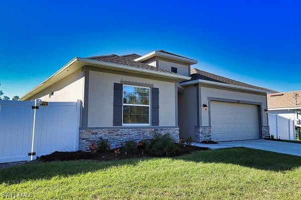 3393 Kacher Rd, North Port, FL 34288 - prairie-style home featuring stone siding, an attached garage, driveway, and stucco siding
