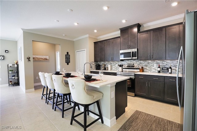 3393 Kacher Rd, North Port, FL 34288 - kitchen with appliances with stainless steel finishes, a kitchen bar, tasteful backsplash, light tile patterned floors, and a kitchen island with sink