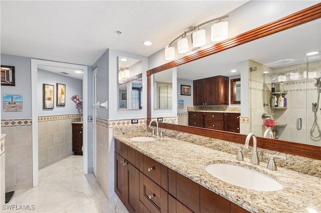 4745 Estero Blvd Unit 1002, Fort Myers Beach, FL 33931 - bathroom featuring tile walls, double vanity, a stall shower, marble finish floors, and a wainscoted wall