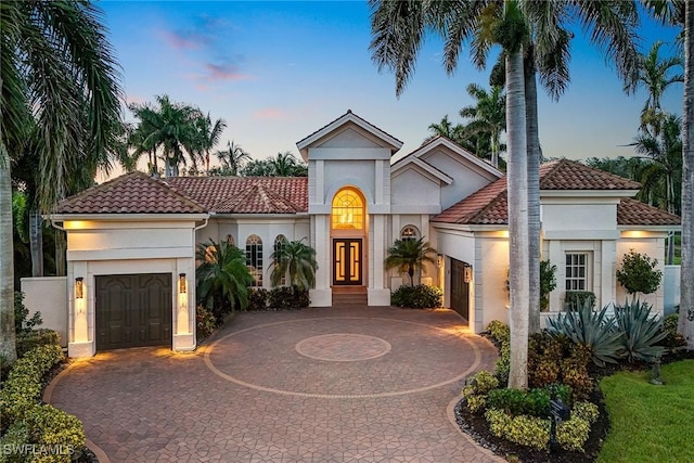 12850 Terabella Way, Fort Myers, FL 33912 - mediterranean / spanish house featuring stucco siding, curved driveway, a tile roof, and an attached garage