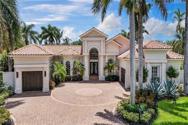12850 Terabella Way, Fort Myers, FL 33912 - mediterranean / spanish home featuring an attached garage, curved driveway, and stucco siding