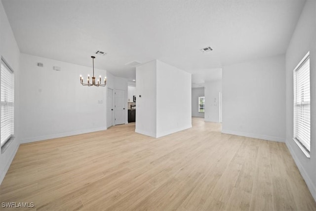 11544 Lake Cypress Loop, Fort Myers, FL 33913 - unfurnished living room with a chandelier, light wood-style flooring, and healthy amount of natural light