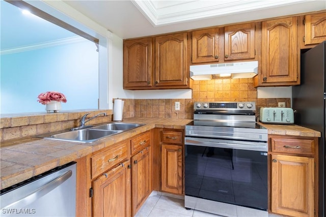 1014 Pine Isle Ln Unit 1014, Naples, FL 34112 - kitchen featuring appliances with stainless steel finishes, under cabinet range hood, ornamental molding, tile countertops, and light tile patterned floors