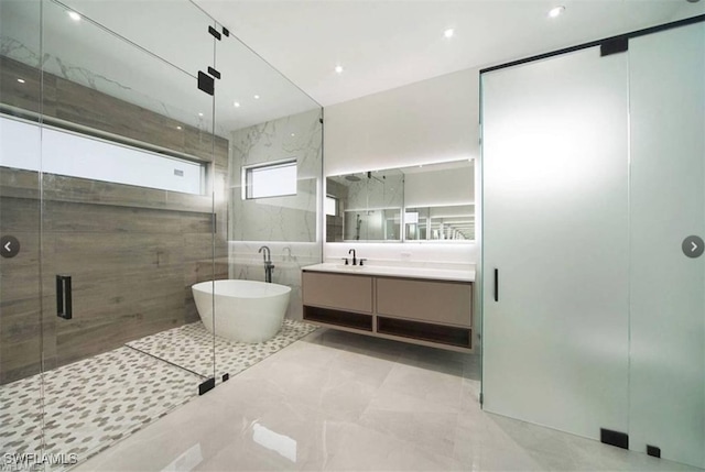 4612 SW 22nd Pl, Cape Coral, FL 33914 - full bathroom featuring vanity, a freestanding tub, a shower stall, tile patterned flooring, and tile walls
