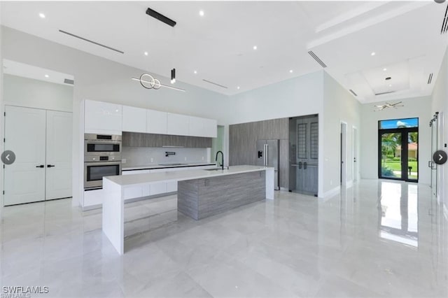 4612 SW 22nd Pl, Cape Coral, FL 33914 - kitchen featuring modern cabinets, appliances with stainless steel finishes, a high ceiling, white cabinets, and light countertops