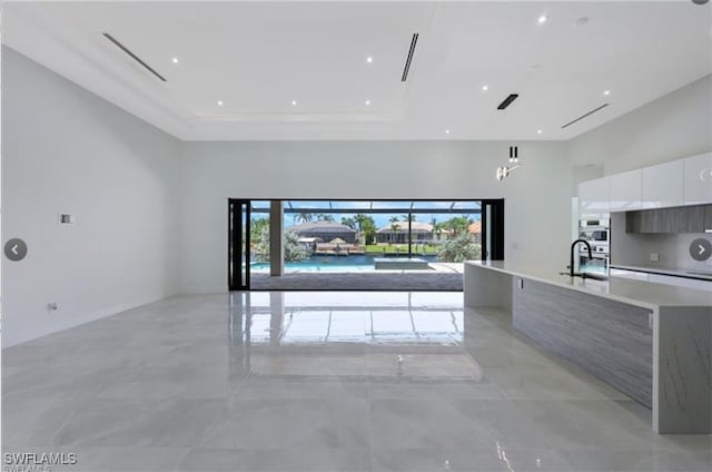 4612 SW 22nd Pl, Cape Coral, FL 33914 - unfurnished living room with a tray ceiling and a towering ceiling
