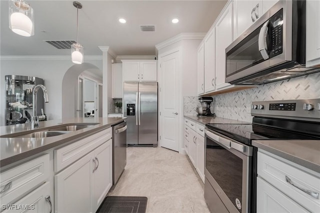 19855 Beverly Park Rd, Estero, FL 33928 - kitchen featuring appliances with stainless steel finishes, crown molding, arched walkways, backsplash, and decorative light fixtures