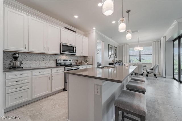 19855 Beverly Park Rd, Estero, FL 33928 - kitchen featuring stainless steel appliances, crown molding, decorative backsplash, a kitchen island with sink, and a breakfast bar area