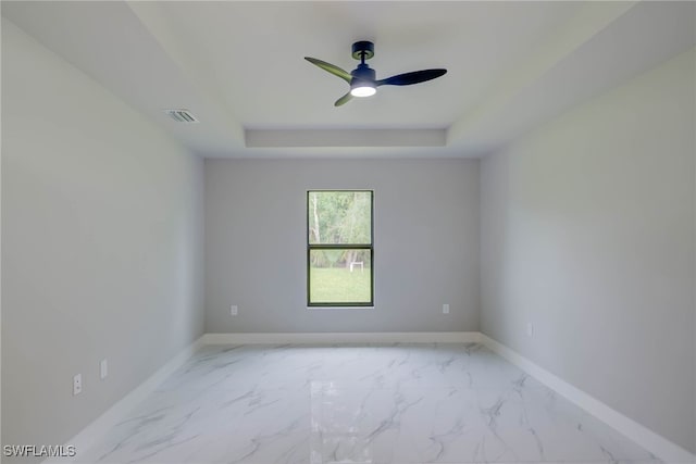 3606 51st St W, Lehigh Acres, FL 33971 - unfurnished room with a raised ceiling, marble look tile flooring, and ceiling fan