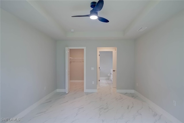 3606 51st St W, Lehigh Acres, FL 33971 - unfurnished bedroom with a walk in closet, a raised ceiling, a closet, light marble finish floors, and a ceiling fan