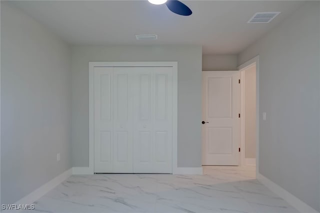 3606 51st St W, Lehigh Acres, FL 33971 - unfurnished bedroom featuring marble look tile flooring, a closet, and a ceiling fan