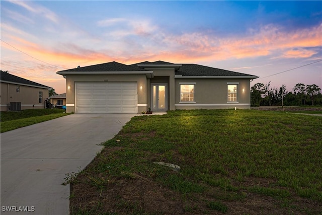 3111 11th St W, Lehigh Acres, FL 33971 - prairie-style house featuring concrete driveway, an attached garage, stucco siding, and a front lawn