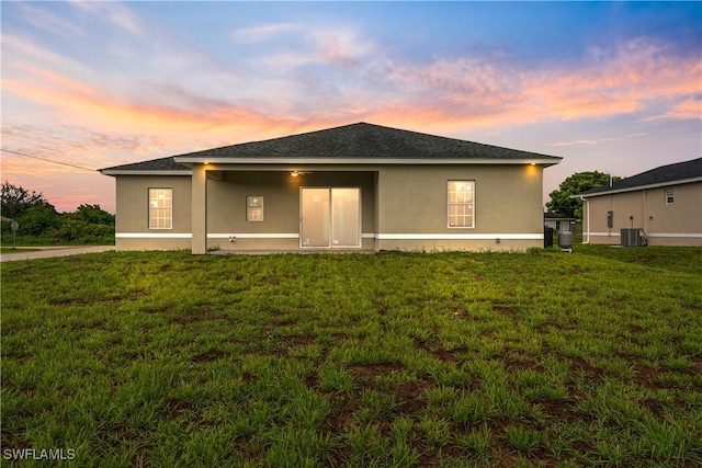 3111 11th St W, Lehigh Acres, FL 33971 - back of house at dusk with stucco siding and a yard
