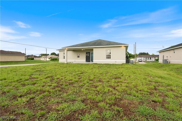 3111 11th St W, Lehigh Acres, FL 33971 - back of house featuring a lawn and stucco siding