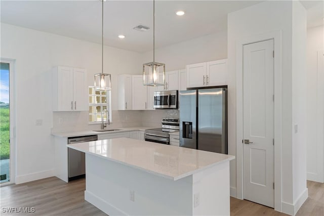 3111 11th St W, Lehigh Acres, FL 33971 - kitchen with stainless steel appliances, light wood-style flooring, backsplash, white cabinetry, and recessed lighting