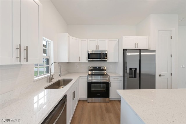 3111 11th St W, Lehigh Acres, FL 33971 - kitchen featuring appliances with stainless steel finishes, white cabinetry, light stone countertops, and decorative backsplash