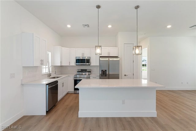 3111 11th St W, Lehigh Acres, FL 33971 - kitchen with appliances with stainless steel finishes, light wood-type flooring, tasteful backsplash, white cabinets, and light countertops