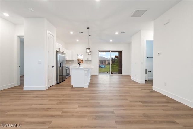 3109 11th St W, Lehigh Acres, FL 33971 - kitchen featuring stainless steel refrigerator with ice dispenser, open floor plan, light countertops, white cabinetry, and recessed lighting