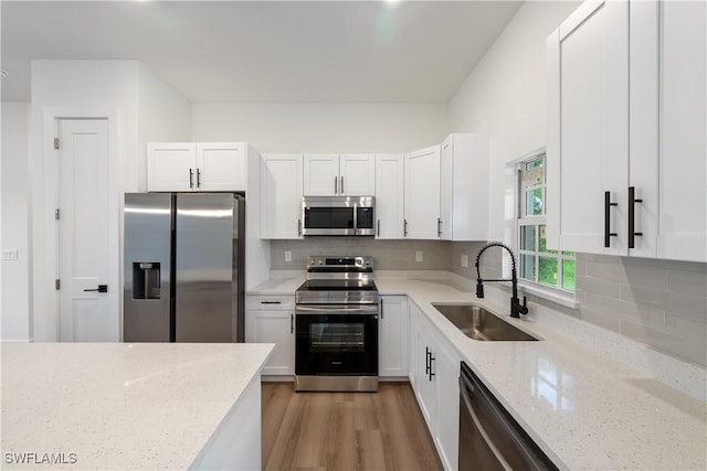 3109 11th St W, Lehigh Acres, FL 33971 - kitchen with appliances with stainless steel finishes, white cabinets, light stone countertops, and backsplash