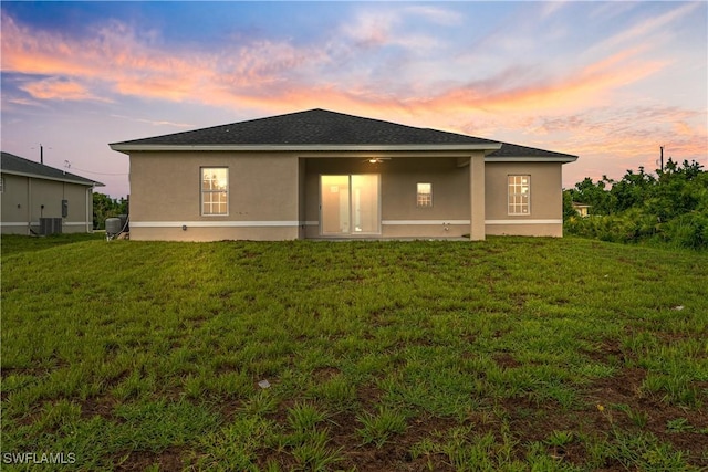 3109 11th St W, Lehigh Acres, FL 33971 - back of property with stucco siding and a lawn